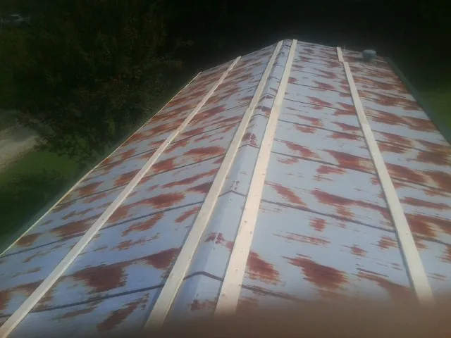 Rusted metal roof panels with new wood purlins before replacement — Storm Damage Roof Repair in Webster by Roofing Brothers